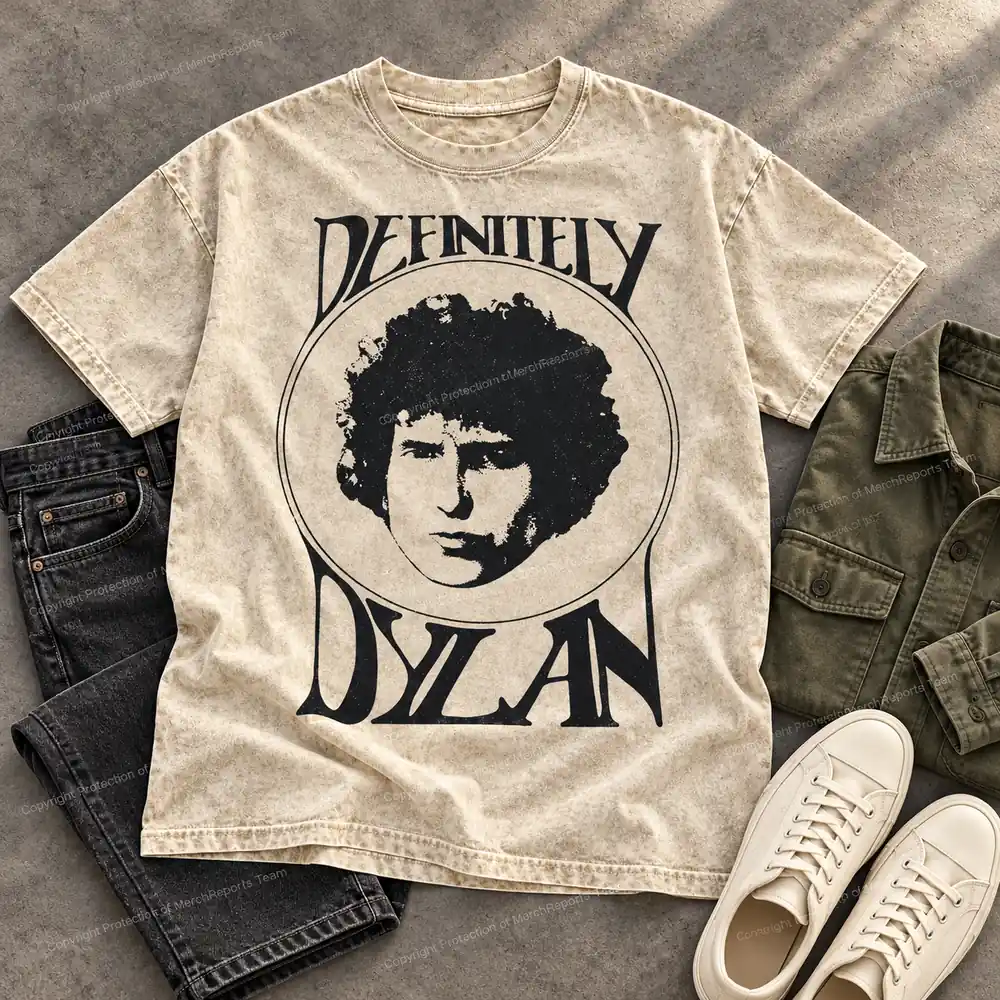Editorial flat mockup of the beige Definitely Dylan tee with neutral outfit pieces