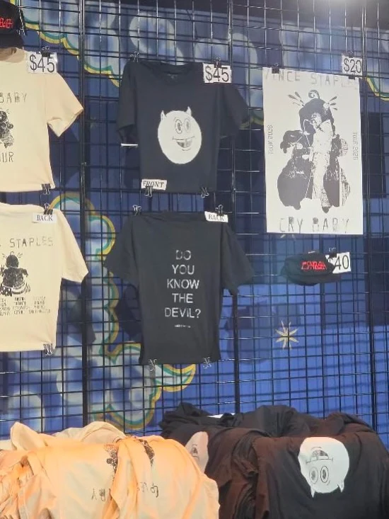 Black graphic tee beside the Cry Baby poster and black cap